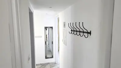 a hallway with a mirror and a chandelier on the wall at Luxurious 2BR Apartment in City Center with Internet in Larnaka