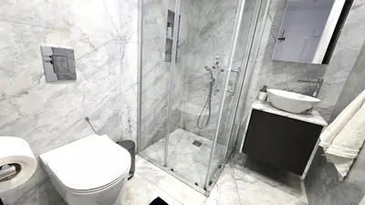 a bathroom with a shower and a toilet and a sink at Luxurious 2BR Apartment in City Center with Internet in Larnaka