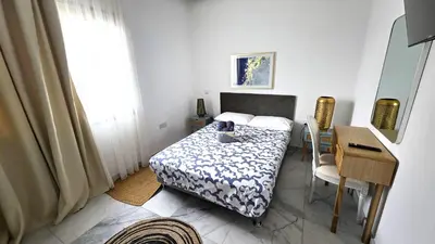 a bedroom with a bed and a table and a desk at Luxurious 2BR Apartment in City Center with Internet in Larnaka