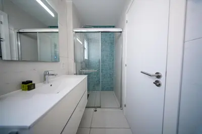 a white bathroom with a shower and a sink at Sunset Family Villa w heated pool - 1Min Walk to Beach in Protaras