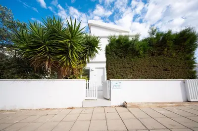 a white fence in front of a white house at Sunset Family Villa w heated pool - 1Min Walk to Beach in Protaras