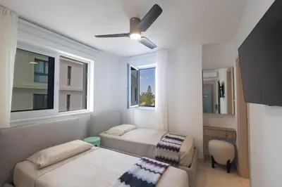 a room with two beds and a ceiling fan at Mackenzy Dream Residence 202 in Larnaka