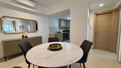a dining room with a white table and chairs at Zavos Aqua Park Club Apt by TrulyCyprus in Limassol