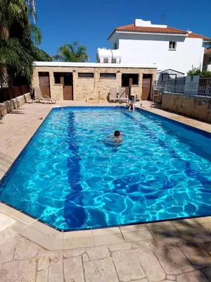 a person swimming in a large blue swimming pool at Modern Holiday Appartment With Pool in Paralimni