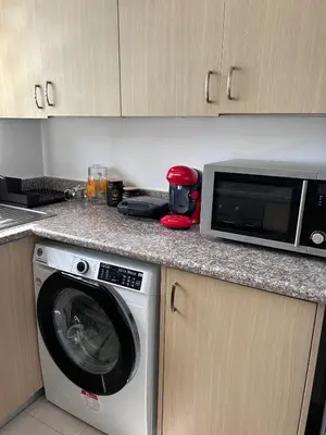 a kitchen with a washing machine and a microwave at Modern Holiday Appartment With Pool in Paralimni