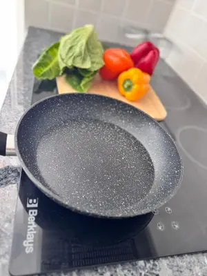 a skillet on a cutting board with vegetables on a counter at Nissini Wana Luxury Villa in Ayia Napa