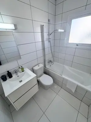 a white bathroom with a toilet and a sink at Nissini Wana Luxury Villa in Ayia Napa