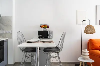 a kitchen with a white table and two chairs at Tangerine Modern 1-BR Apartment in Larnaca in Larnaka