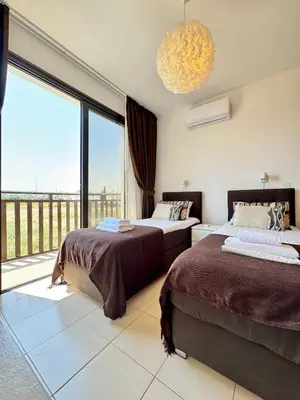 a bedroom with two beds and a large window at Villa ILIOS Cozy 2BR with Pool in Paralimni