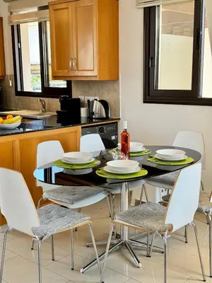 a kitchen with a table and chairs in a kitchen at Villa ILIOS Cozy 2BR with Pool in Paralimni