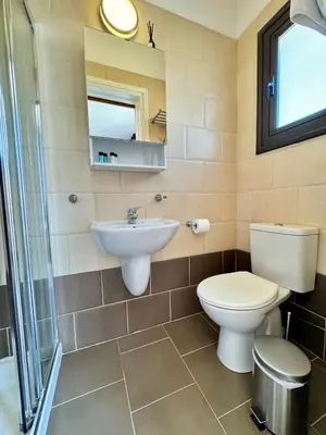 a bathroom with a toilet and a sink and a mirror at Villa ILIOS Cozy 2BR with Pool in Paralimni