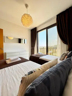 a bedroom with two beds and a large window at Villa ILIOS Cozy 2BR with Pool in Paralimni