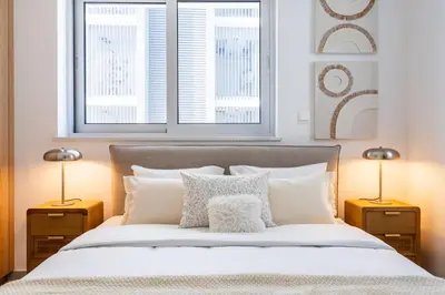 a bedroom with a large bed with two lamps at Aelia - Chic 2-BR Apartment & Balcony in Larnaca in Larnaka