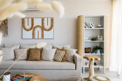 a living room with a couch and a mirror at Aelia - Chic 2-BR Apartment & Balcony in Larnaca in Larnaka