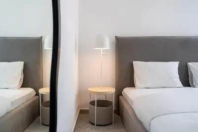 a bedroom with two beds and a lamp on a table at Solara - Stylish Balcony Apartments in Larnaca in Larnaka