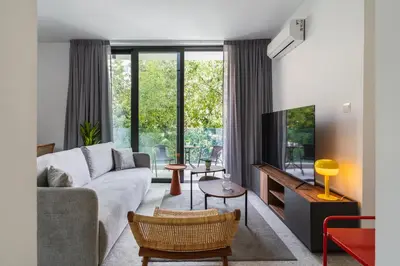 a living room with a couch and a tv at Solara - Stylish Balcony Apartments in Larnaca in Larnaka