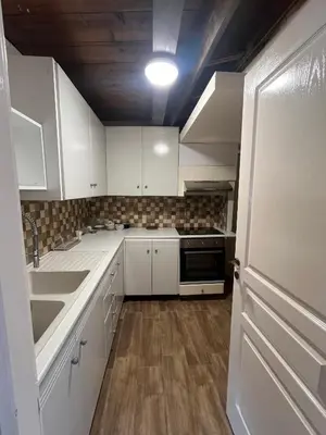 a kitchen with white cabinets and a sink at Odou Residence in Odhou