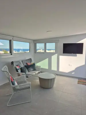 a living room with chairs and a couch and a tv at Konnos Studio in Protaras