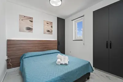 a bedroom with a bed with two white shoes on it at Modern 2BR Apartment Near Ayia Napa - Anastasia 101 in Xylophaghou
