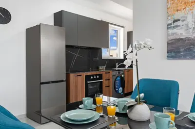 a kitchen with a table and a refrigerator at Modern 2BR Apartment Near Ayia Napa - Anastasia 101 in Xylophaghou
