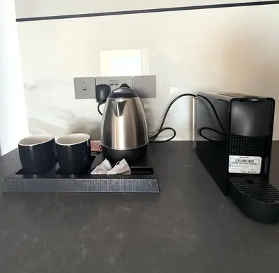 a kitchen counter with a coffee pot and two cups at 201 Lux Suite Tower206 in Lakatamia