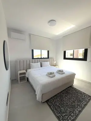 a white bedroom with a large bed and a rug at 201 Lux Suite Tower206 in Lakatamia