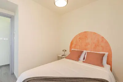 a bedroom with a large bed with an orange headboard at Cozy apartment in Larnaca City Center in Larnaka
