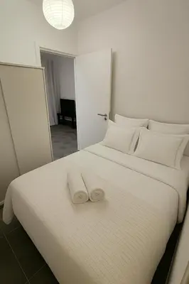 a white bed with two towels on top of it at Studio by The Sea in Limassol