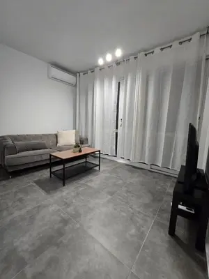 a living room with a couch and a table at Studio by The Sea in Limassol
