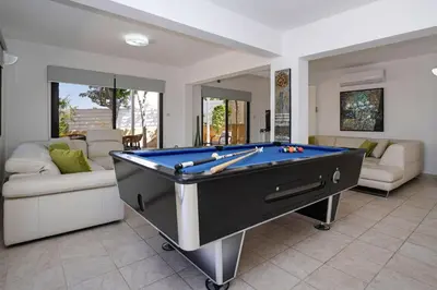 a pool table in a living room with at Villa GreenWay - Large Private Pool in Protaras