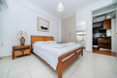 a bedroom with a large bed and a table with a lamp at Seafront central 1 bedroom flat in Limassol