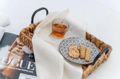 a basket with a plate of biscuits and a glass of tea at Seafront central 1 bedroom flat in Limassol