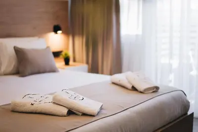 a hotel room with a bed with towels on it at Kition Urban Suite 3 in Larnaka