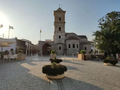 a building with a clock tower in a courtyard at Mackenzie Beach Apartment in Larnaka