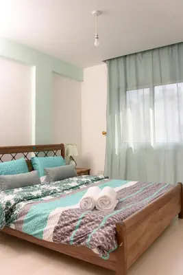 a bedroom with a bed with towels on it at Green Island Apartment 102 in Larnaka