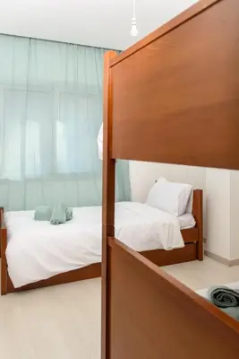 a bedroom with two bunk beds with white sheets at Green Island Apartment 102 in Larnaka