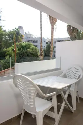 two white chairs and a table on a balcony at Green Island Apartment 102 in Larnaka