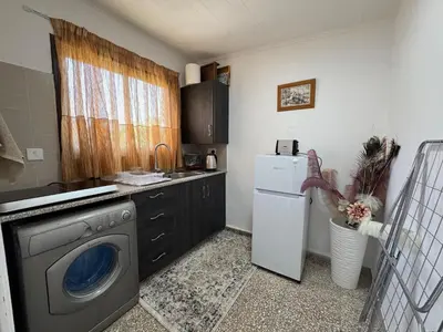 a kitchen with a washing machine and a refrigerator at Mackenzie By the sea one bed Ground floor home in Larnaka