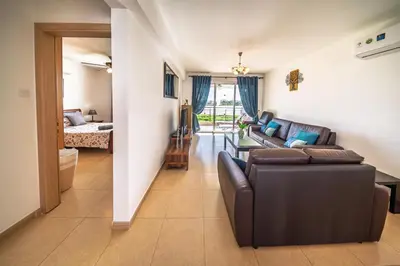 a living room with a couch and a table at Chromata Lagoon Sea View Apartment in Paralimni