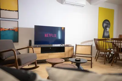 a living room with a tv and chairs at Vivid Stays Chalkokondili in Nicosia