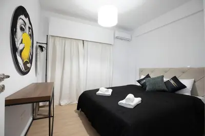 a bedroom with a black bed with two white towels on it at Vivid Stays Chalkokondili in Nicosia