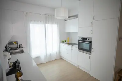 a white kitchen with white cabinets and a window at Vivid Stays Chalkokondili in Nicosia