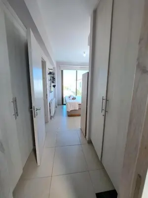 a hallway with white doors and a room with a bed at Villa Allamare with a pool in Paralimni