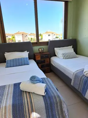 two beds in a room with two windows at Villa Allamare with a pool in Paralimni