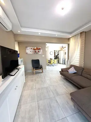 a living room with a couch and a flat screen tv at Villa Allamare with a pool in Paralimni