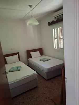 two beds in a small room with a window at Big house in center of protaras, near beach in Protaras