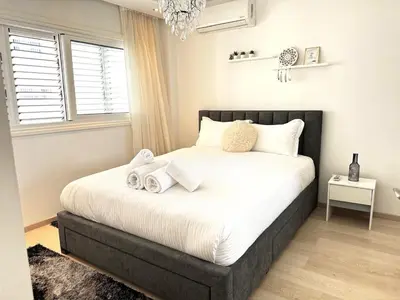 a bedroom with a bed with towels on it at Wealthystays Duplex in the Heart of Nicosia in Nicosia