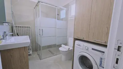 a bathroom with a washing machine and a sink at STAY Sunny Honey Apartment in Ayia Napa