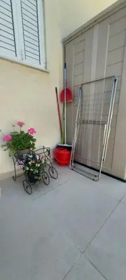 a garage with a gate and two plants and flowers at Sea Breeze Maisonette in Larnaka