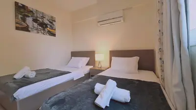 two beds sitting next to each other in a room at STAY Suncity Apartment in Larnaka